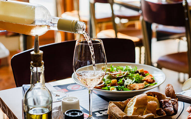 weißwein wird zu leckerem essen serviert